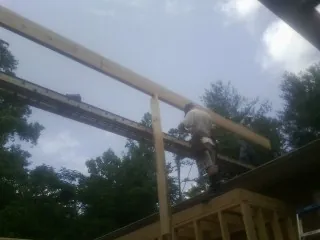 Carpenter setting a ridge beam over a new addition frame — Ice Dam Removal by Roofing Brothers in Arock