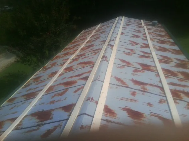 Rusted metal roof panels with new wood purlins before replacement — Storm Damage Roof Repair in Arock by Roofing Brothers