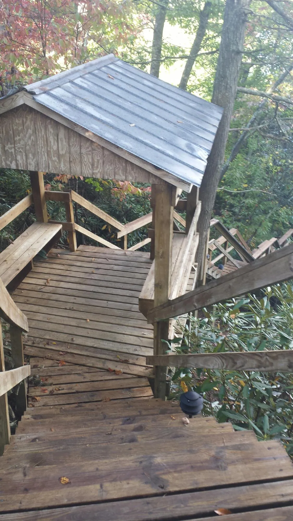 Metal roofed shelter over wooden steps on a wooded walkway — Skylight Repair & Installation work by our crew in Arock