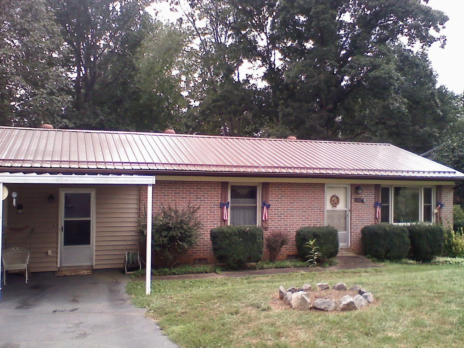 Bronze metal roof and carport on a brick ranch home — Roof Repair work by our crew in Arock