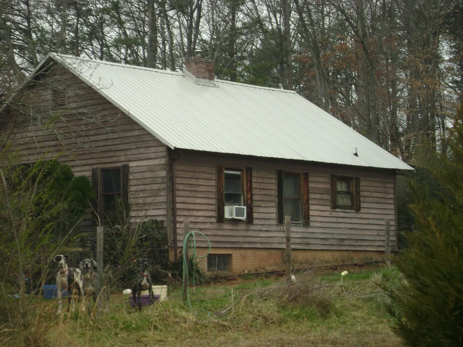 White metal roof on an old wood sided farmhouse, from a Metal Roof Installation job in Arock